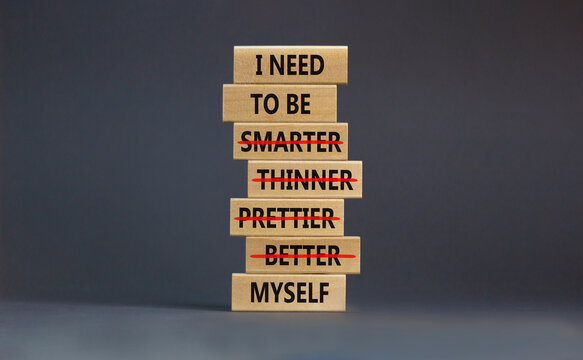 Be myself symbol. Businessman hand. Wooden blocks with words 'i need to be myself, not smarter, thinner, prettier, better'. Beautiful grey background, copy space. Psychological, be myself concept.