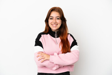 Young redhead woman isolated on white background keeping the arms crossed in frontal position