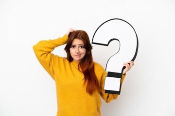Young redhead woman isolated on white background holding a question mark icon and having doubts