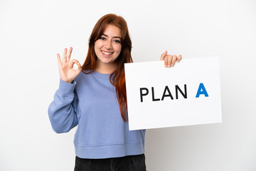 Young redhead woman isolated on white background holding a placard with the message PLAN A with ok sign