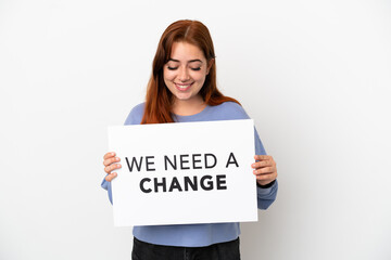 Young redhead woman isolated on white background holding a placard with text We Need a Change