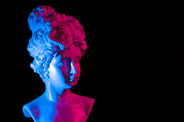 Portrait of a puppet woman on black. Plaster girl face in neon blue pink color. Female beauty concept, perfect face proportion
