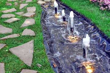 Artificial PVC Pond in Garden with Lanterns and Fountains. Small Decorative Pond or Brook in...