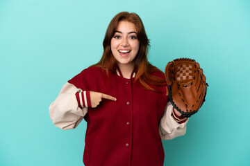 Young redhead woman playing baseball isolated on blue background with surprise facial expression
