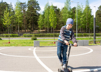 boy with a scooter having fun in the park in the spring