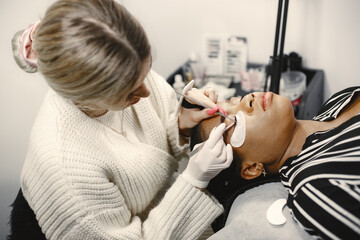 Fototapeta premium African girl grows eyelashes in salon