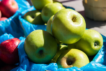 A bushel of apples sit on a table during a festival.
