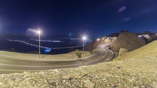Day to night transition timelapse with rocks and Curvy road on Jebel Hafeet. Mountain located primarily in the environs of Al Ain and offers an impressive view over the city. Aerial view from top