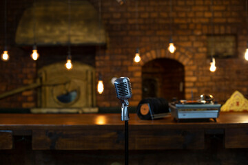 Retro microphone on stage. Warm lights behind.
