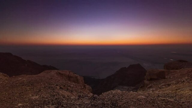 Sunset with rocks timelapse from Jebel Hafeet, mountain located primarily in the environs of Al Ain and offers an impressive view over the city. Aerial view from top