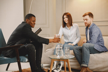Fototapeta premium Male psychoterapist giving water to man on therapy session