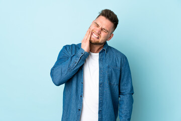 Russian handsome man isolated on blue background with toothache