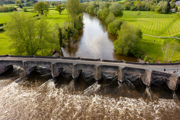 Aerial view of an old bridge across a fast flowing river
