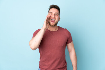 Russian handsome man over isolated background shouting with mouth wide open