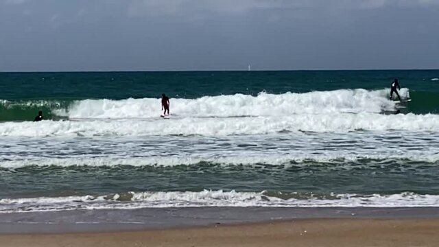 Serfers and serfing at Tel Baruch Mediterranean sea beach. Tel Aviv, Israel.  HD