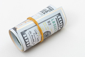 US dollar rolled up with a rubber band isolated on white. the most popular money.