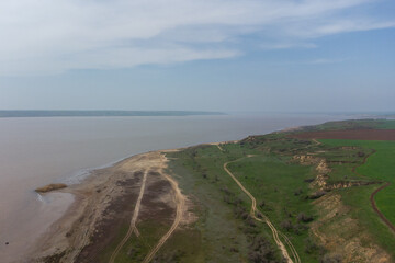 Fototapeta na wymiar The coast of the Kuyalnitsky estuary in the spring. Sandy cliff, beach and pond. Aerial view.