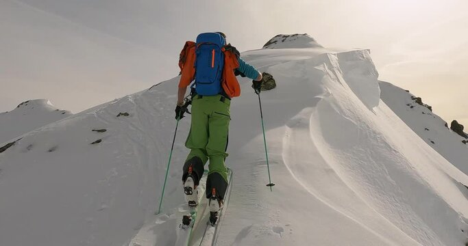 Ski touring with a ski mountain guide on top of the mountain in tyrol. Lonely ski touring high up in the mountains. Freedome at the mountain top. Ski mountaineering in Austria. 4K follow camera.