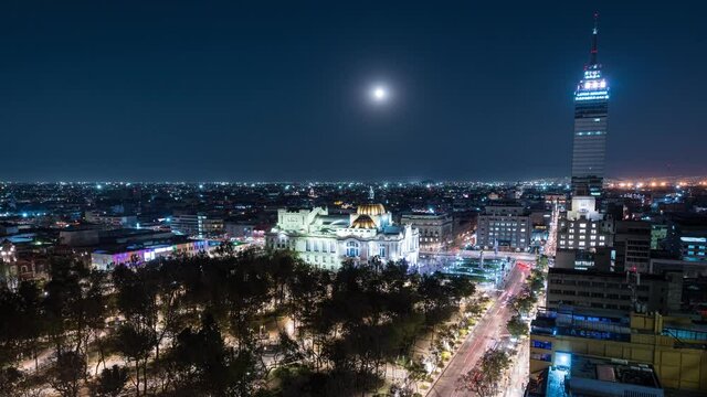 Night Time lapse of the Palace of Fine Arts, Juarez avenue and Alameda Central city park  with a rising full moon. Mexico City