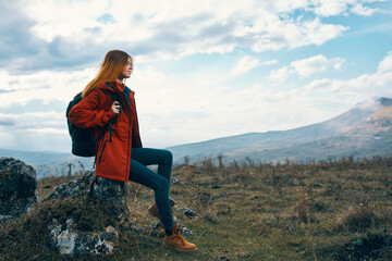 Naklejka premium woman on nature in the mountains sits on a stone and autumn landscape