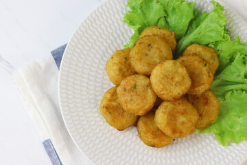 Perkedel Kentang or Potato cutlet, one of Indonesian food made from mashed potato, celery, spice, and fried. White marble background, copy space for text
