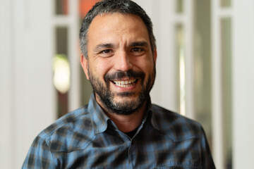 Obraz premium Front view portrait of happy smiling caucasian mature man with beard and short hair looking to the camera standing at office or home wearing shirt