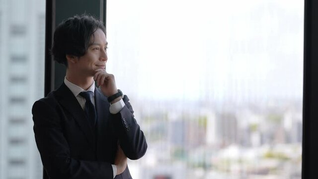ビルの景色を眺めるビジネスマン