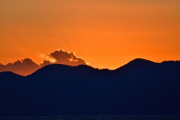 真っ赤な夕焼けに染まる支笏湖の山並みの情景＠北海道