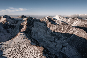 Fototapeta na wymiar Aerial view of Mountain peaks in snow at sunset.