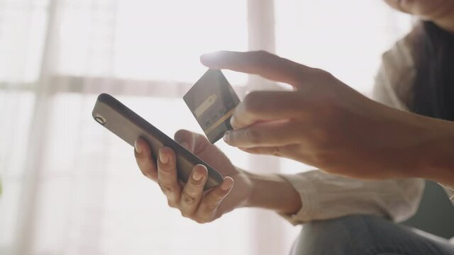 Hand of Asian women are buying online with a credit card on smartphone