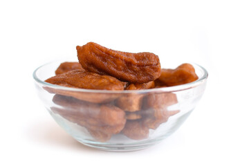 Sun-dried bananas in glass bowl on white background.