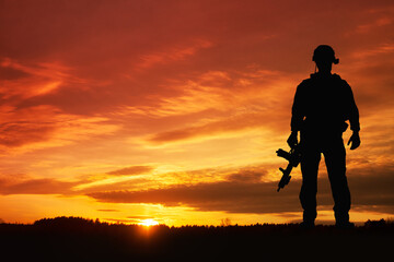 Fototapeta na wymiar Silhouette of a soldiers against the sunrise. Concept - protection, patriotism, honor.