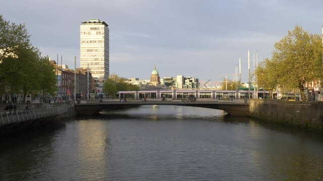 SIPTU Headquarter At Liberty Hall With Tram Crossing Rosie Hackett Bridge In Dublin, Ireland. - wide shot