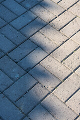 The texture concrete paving slabs. Bacground image of paving tile of the street. Cement brick stone floor with interesting shadows. 