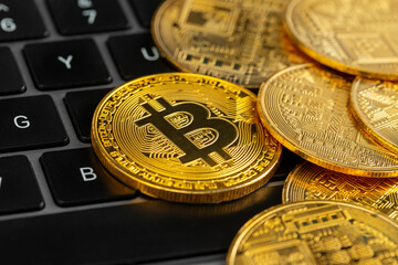 Gold bitcoin coins on laptop keyboard