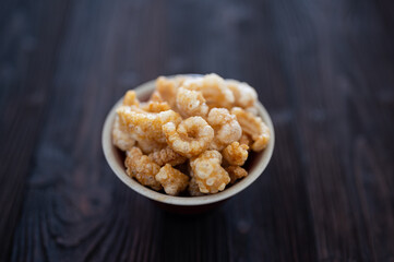 Homemade deep fried crispy pork rind in bowl.