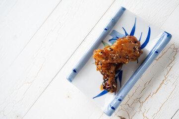Sour-sweet baked chicken wings sesame and  teriyaki sauce.