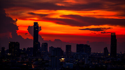Fototapeta premium Panorama background of city views, with colorful twilight sky, high-rise buildings (condominiums, offices, expressways) and blurred lights from roads and traffic.
