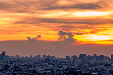 Panorama background of city views, with colorful twilight sky, high-rise buildings (condominiums, offices, expressways) and blurred lights from roads and traffic.