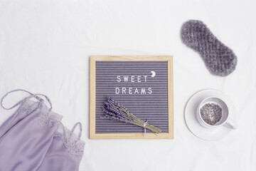 Healthy night sleep concept, cup of lavender tea, pajamas, mask, aromas for better falling asleep,...