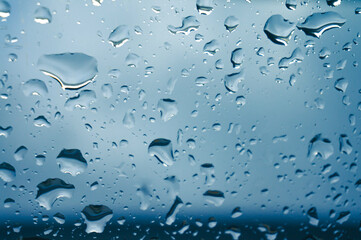 Rain drops on window glasses surface with sunset. drops on glass spray on window background for dark text view selective focus