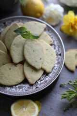 Lemon biscuits with basil on a table with floral decoration. Cookies and spring decor. Crunchy dessert.