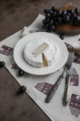 Fototapeta na wymiar Camembert on a white plain plate. White cheese. Minimalistic photo.
