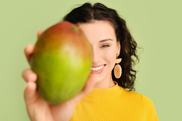 Beautiful woman with fresh mango on color background