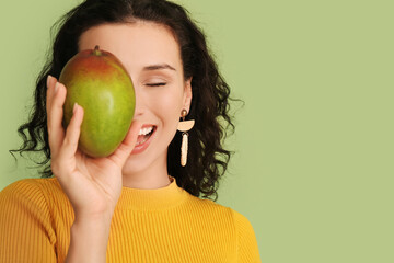Beautiful woman with fresh mango on color background