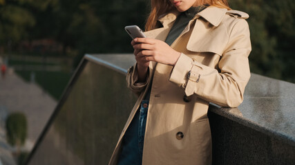 Close up girl dressed in trench coat looking stylish chatting in