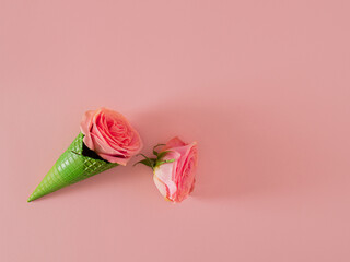 fresh pink roses with fresh green ice cream cone on the summer pastel pink background. tropical abstract art. minimal flat lay background idea with copy space