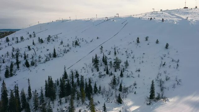 Aerial view overlooking the slopes at the Olostunturi ski center, in Lapland - reverse, drone shot