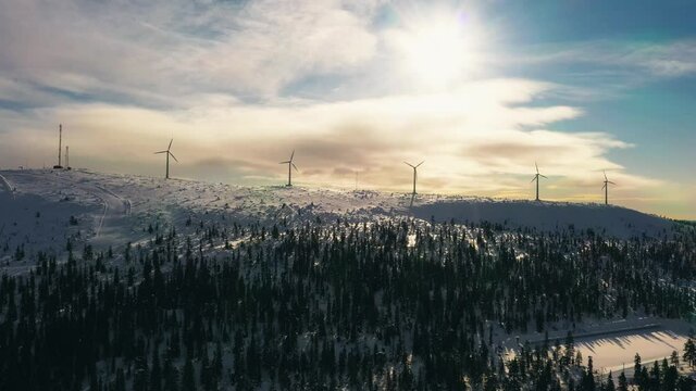 Aerial view of windmills on top of the Olostunturi mountain, sunny evening in Olos, Lapland - tracking, drone shot