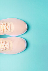 Peach sneakers on green background. Concept of healthy lifestile, everyday training and yoga.